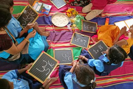 Students writing OMKARA on the Slate 